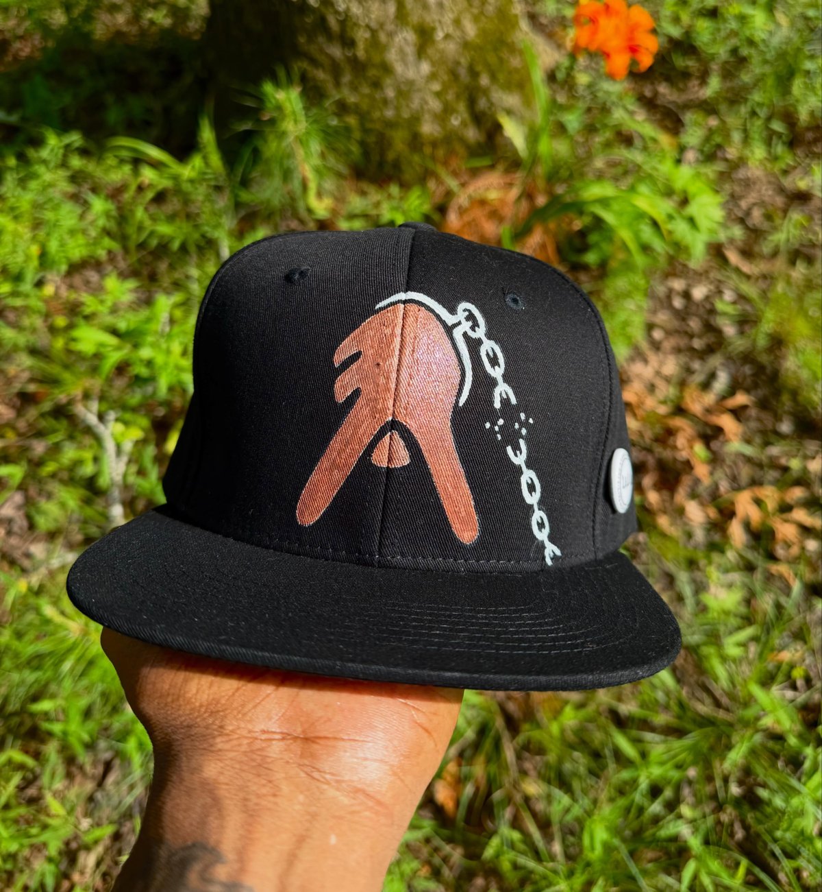 Hand-painted A-Town Juneteenth 1865 snapback, held up outdoors